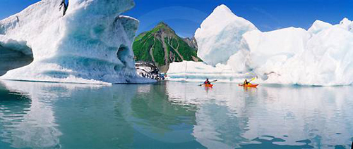 Kayakers dwarfed by enormous icebergs navigate Bear Lake fed by Bear Glacier, Kenai Fjords National Park, Alaska